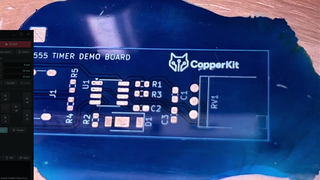 Die blaue 555-Timer-Platine mit freigelegten Kupferpads und weißen Bauteilmarkierungen.